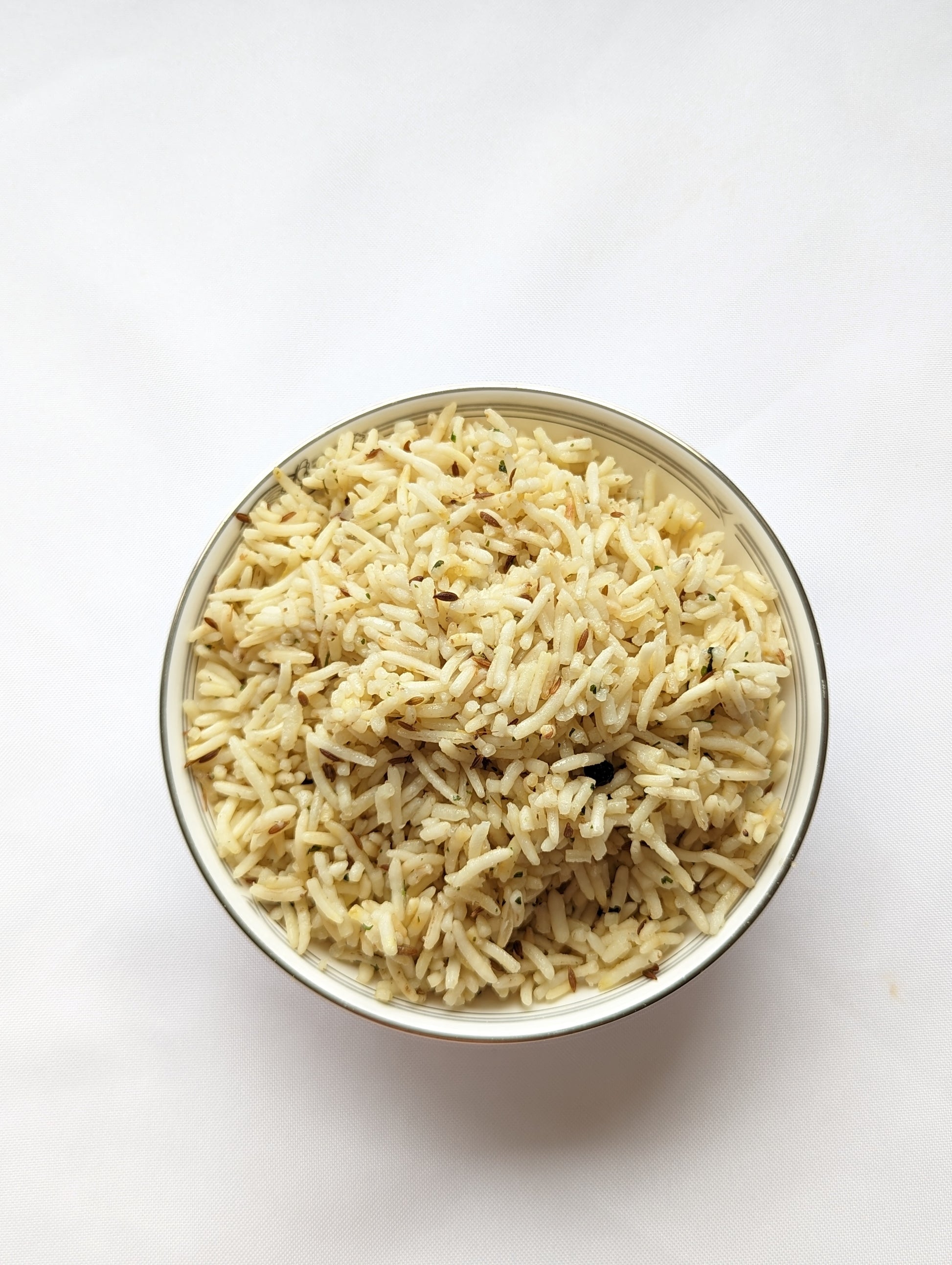 Authentic home-cooked Indian jeera rice on white background